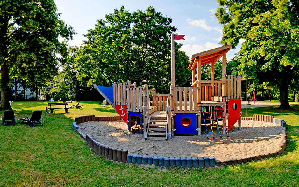 Klettergerüst in Schiffsform auf der Grünfläche vom Freibad am Taubertsbergbad