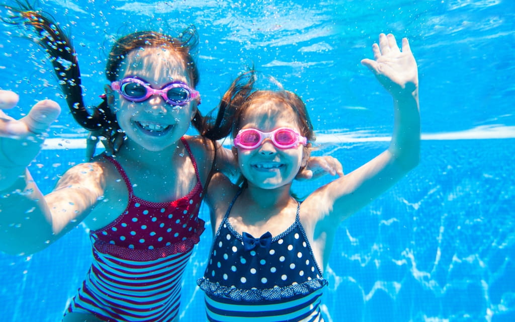 Zwei kleine Mädchen tauchen unter Wasser
