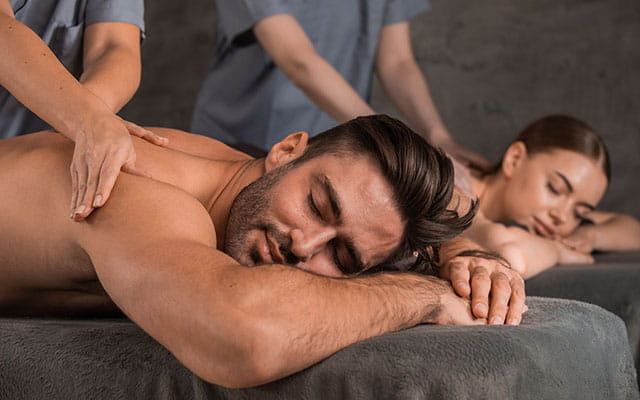 Ein Mann und eine Frau liegen im Spa und werden massiert