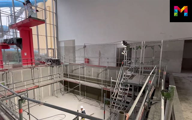Sprungturm neben einem Schwimmbecken auf einer Baustelle im Schwimmbad