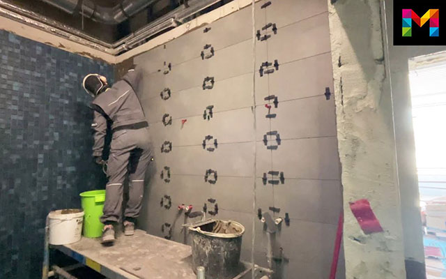 Ein Mann arbeitet auf einer Baustelle an der Wand